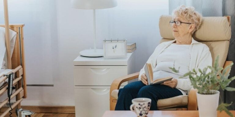 Elderly Woman Reads Peacefully in Comfortable Living Space at Assisted Living Facility