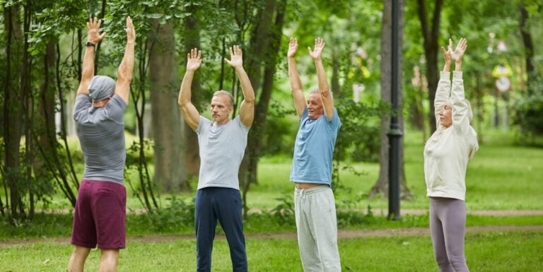 Group of Elderly Adults Stretching Outdoors at an Assisted Living Facility