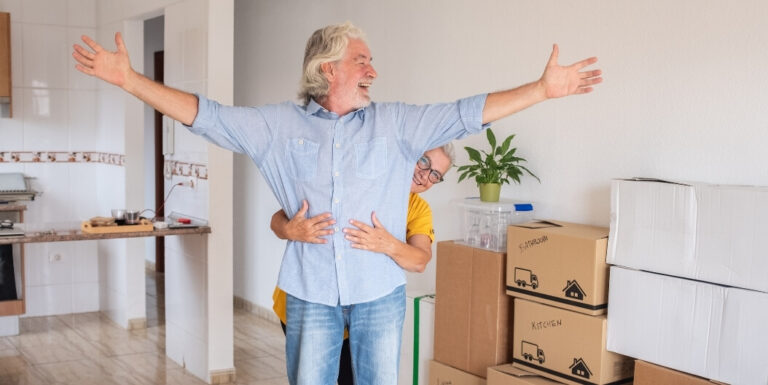 Joyful Elderly Couple Unpacking Moving Boxes in Their New Assisted Living Facility